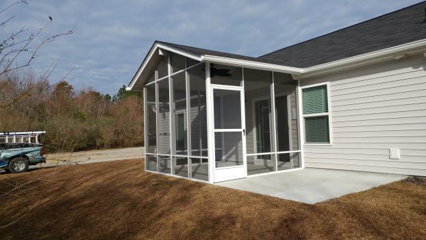 A beautiful exterior photo of a screened addition.